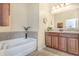 Well-lit bathroom with a soaking tub and a dual sink vanity with dark wood cabinets at 3471 Julius Estates Blvd, Winter Haven, FL 33881