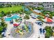 Aerial view of a water park with colorful slides, pools, and lush landscaping in a community at 385 Southfield St, Kissimmee, FL 34747