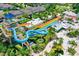 Aerial view of a water park featuring colorful slides, pools, and a splash pad in a community of houses at 385 Southfield St, Kissimmee, FL 34747