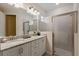 Bathroom featuring a double vanity with granite countertop and walk in shower with glass door at 385 Southfield St, Kissimmee, FL 34747