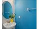 Stylish powder room with a vessel sink, round mirror and a striking blue accent wall at 385 Southfield St, Kissimmee, FL 34747