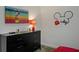 A playful bedroom featuring a Mickey Mouse theme, dresser, and an entertainment center at 385 Southfield St, Kissimmee, FL 34747