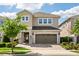 Charming two-story home featuring a stone-accented facade, paver driveway, and a well-maintained lawn at 385 Southfield St, Kissimmee, FL 34747
