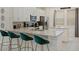 Modern kitchen featuring stainless steel appliances, granite countertops, and stylish emerald green bar stools at 385 Southfield St, Kissimmee, FL 34747