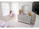 Bright bedroom featuring a modern dresser, large windows, and plush carpet flooring at 3920 Reed Grass Pl, Kissimmee, FL 34746