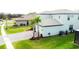 Beautiful light-colored two-story home boasts well manicured lawn and paved driveway with young palm trees at 3920 Reed Grass Pl, Kissimmee, FL 34746