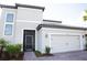 Inviting front of the home with a two-car garage, tile roof, and a screened entry, with fresh landscaping at 3920 Reed Grass Pl, Kissimmee, FL 34746