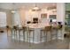 Spacious kitchen with an island, seating, white cabinets, stainless steel appliances and modern pendant lighting at 3920 Reed Grass Pl, Kissimmee, FL 34746