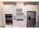 Modern kitchen features stainless steel appliances, white cabinets, stylish hardware and tile backsplash at 3920 Reed Grass Pl, Kissimmee, FL 34746