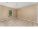 Neutral bedroom with tiled floor and natural light from the window at 502 Woodland Creek Blvd, Kissimmee, FL 34744
