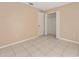Well-lit bedroom with tiled floor, closet, and neutral walls at 502 Woodland Creek Blvd, Kissimmee, FL 34744