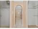 Hallway with open closet space and a laundry area with tile flooring and an archway at 502 Woodland Creek Blvd, Kissimmee, FL 34744