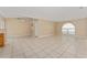 Bright living room featuring tile flooring and an arched window for natural light at 502 Woodland Creek Blvd, Kissimmee, FL 34744