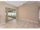 Spacious living room featuring tile flooring and a glass sliding door that leads to a lanai at 502 Woodland Creek Blvd, Kissimmee, FL 34744