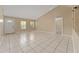 Spacious living room featuring neutral tile flooring, plenty of natural light and a view of the entry door at 502 Woodland Creek Blvd, Kissimmee, FL 34744
