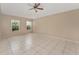 Open main bedroom with neutral tile flooring, ceiling fan and natural light from the two windows at 502 Woodland Creek Blvd, Kissimmee, FL 34744