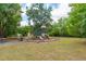 Community playground featuring slides, climbing structures, and seating areas nestled amongst mature trees at 502 Woodland Creek Blvd, Kissimmee, FL 34744