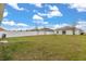 Backyard featuring grass, a white fence and solar panels on the rear of the home at 541 Jerry Ln, Haines City, FL 33844