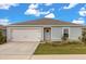 Charming single-story home showcasing a well-manicured lawn, attached garage, and lovely front door with a welcoming wreath at 541 Jerry Ln, Haines City, FL 33844