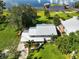 Aerial view of home with metal roof, lush landscaping and driveway leading to the backyard with lake access at 6100 Alligator Lake W Shr, St Cloud, FL 34771