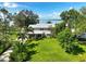 Aerial view of a charming two-story home surrounded by lush landscaping and a serene lake backdrop at 6100 Alligator Lake W Shr, St Cloud, FL 34771