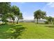 Spacious green backyard featuring mature trees, lush grass, and waterfront views at 6100 Alligator Lake W Shr, St Cloud, FL 34771