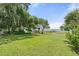 Expansive backyard with lush grass, mature trees, and waterfront views of the lake at 6100 Alligator Lake W Shr, St Cloud, FL 34771