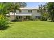 Charming two-story home with a metal roof, surrounded by lush landscaping, and a green lawn at 6100 Alligator Lake W Shr, St Cloud, FL 34771