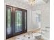 Elegant foyer with decorative glass door, chandelier lighting, and carpeted stairs at 6100 Alligator Lake W Shr, St Cloud, FL 34771