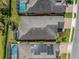 Aerial view of the house showcasing the roof and backyard with a screened-in pool in a residential neighborhood at 688 Cordoba Dr, Davenport, FL 33837
