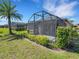 Lush backyard showcasing a screened-in patio, offering a serene retreat with well-manicured landscaping at 688 Cordoba Dr, Davenport, FL 33837