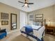 Cozy bedroom with a comfortable bed featuring blue and white bedding, complemented by stylish decor and a mirror at 688 Cordoba Dr, Davenport, FL 33837