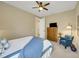 Relaxing bedroom featuring a queen bed with blue accents, a comfortable chair, and a dresser with a television at 688 Cordoba Dr, Davenport, FL 33837