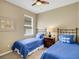 Comfortable bedroom with two twin beds featuring blue bedding, accompanied by a central nightstand and soft lighting at 688 Cordoba Dr, Davenport, FL 33837
