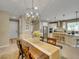 Open dining and kitchen area with modern chandelier, white cabinets, and breakfast bar at 688 Cordoba Dr, Davenport, FL 33837
