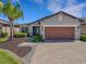 Beautiful single-story home with a brick driveway, stone accents, and a two-car garage at 688 Cordoba Dr, Davenport, FL 33837