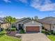 Well-maintained home with a brick driveway, lush landscaping, and a two-car garage at 688 Cordoba Dr, Davenport, FL 33837