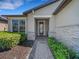 Inviting front porch with stone accents and walkway leading to the decorative glass front door at 688 Cordoba Dr, Davenport, FL 33837