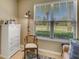 Well-lit home office featuring a large window with blinds, a comfortable chair, and a storage cabinet at 688 Cordoba Dr, Davenport, FL 33837
