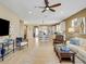 Open-concept living room featuring a ceiling fan, kitchen access, and stylish furnishings at 688 Cordoba Dr, Davenport, FL 33837