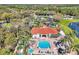 Aerial view of the community clubhouse, pool, and landscaping on a sunny day in a residential area at 8401 Secret Key Cv, Kissimmee, FL 34747