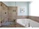 Bathroom with a soaking tub, glass shower, and ceramic tile blends spa-like features with modern design at 8401 Secret Key Cv, Kissimmee, FL 34747