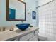 Bathroom featuring blue glass sink bowl, decorative mirror, shower curtain and neutral colors at 8401 Secret Key Cv, Kissimmee, FL 34747