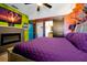 Vibrant bedroom featuring a purple bed, colorful wall art, and unique decorative touches, creating a playful atmosphere at 8401 Secret Key Cv, Kissimmee, FL 34747
