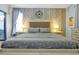 Bright bedroom featuring stylish wallpaper, a decorative clock, and a comfortable bed setting the stage for relaxation at 8401 Secret Key Cv, Kissimmee, FL 34747