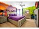 Bright bedroom with whimsical murals, a plush purple bed set, and coordinated decor, creating a cozy and imaginative space at 8401 Secret Key Cv, Kissimmee, FL 34747
