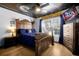 Stylish bedroom with wood accents, dramatic moon-themed ceiling art and wood floors at 8401 Secret Key Cv, Kissimmee, FL 34747