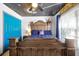Bedroom featuring painted ceiling, natural floors, a wood bed and a blue accent wall at 8401 Secret Key Cv, Kissimmee, FL 34747