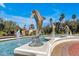 Beautiful dolphin fountain at the community entrance with palm trees and manicured landscaping on a bright, sunny day at 8401 Secret Key Cv, Kissimmee, FL 34747