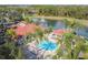 Aerial view of community pool with lake view, fountain, palm trees, lounge chairs and adjacent covered seating area at 8401 Secret Key Cv, Kissimmee, FL 34747